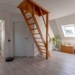 Haus mit Holztreppe zur Dachschräge, Fenster und Pflanzen