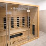 Eine Infrarotsauna mit Holzbank und Glasfront in einem hellen Raum.