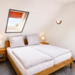 Schlafzimmer mit Doppelbett, zwei Nachttischen und Dachfenster.