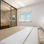 Schlafzimmer mit Doppelbett, Spiegeltüren und Fenster mit Blick.