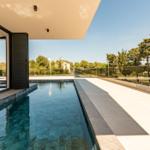 Pool mit Glasgeländer und Blick auf Bäume und Himmel