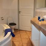 Bad mit Whirlpool, Toilette und Waschtisch mit blauen Kerzen.