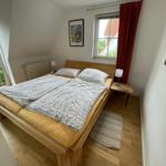 Schlafzimmer mit Doppelbett, Fenster und Holzboden