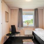 Ein Schlafzimmer mit Bett, Stuhl und Fenster mit Blick auf die Landschaft.
