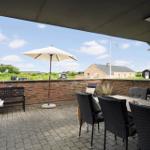 Terrasse mit Sitzgruppe, Sonnenschirm und Blick auf Umgebung.