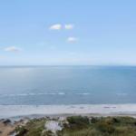 Weiter Blick auf das Meer und den Strand von oben.