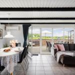 Esszimmer mit Tisch und Stühlen, Wohnbereich mit Sofa und Blick auf Terrasse.