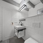 Badezimmer mit Waschbecken, Toilette und Heizung.