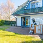 Haus mit Terrasse, Garten und Strandkorb. Tür zum Innenraum.