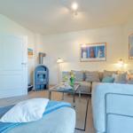 Wohnzimmer mit Sofa, Kamin und Wandbildern