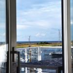 Blick auf Hafen mit Booten und Meer durch große Fenster