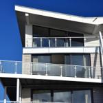 Moderne Wohnung mit Balkon und großen Fenstern unter blauem Himmel