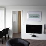 Wohn- und Essbereich mit TV, Kamin und Blick auf Hafen.