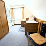 Schlafzimmer mit Bett, Kleiderschrank und Bad im Anschluss