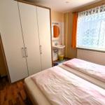 Schlafzimmer mit Doppelbett, Kleiderschrank und Waschbecken