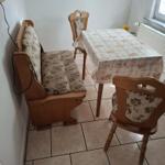 Essbereich mit Tisch, drei Stühlen und Sitzbank. Bodenfliesen und Fenster vorhanden.