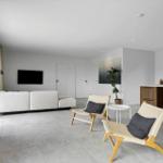 Wohnbereich mit Kamin, Sofa, Stühlen und Küchenzeile.