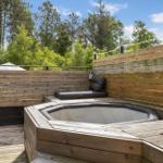 High-quality hot tub platform with wooden surround and bench in garden area.