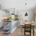 Kitchen with dining area, wooden floor, and window to the outside.