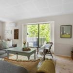 Living room with sofa, coffee table, and view of balcony