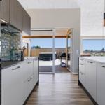 Moderne Küche mit Blick auf Terrasse und Whirlpool.
