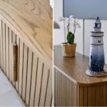 Holzschrank mit vertikalen Paneelen und einer Holztürgriff. Auf dem Schrank steht eine Laterne und eine Orchidee.