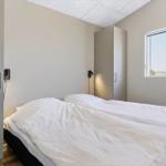 Ein Schlafzimmer mit einem Doppelbett, einem Fenster und einer Garderobe.