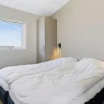 Schlafzimmer mit Doppelbett, Fenster und Kleiderschrank.