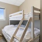 Zimmer mit Doppelstockbett und Fenster mit Blick nach draußen.