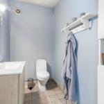Badezimmer mit Waschbecken, Toilette und Handtuchhalter.