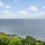 Haus am Meer mit Blick auf Windkraftanlagen