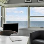 Raum mit Blick auf Meer, Tisch, Stühle und Fenster
