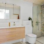 Bad mit Waschbecken, Spiegelschrank, Dusche und Toilette.