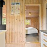Küche mit Holzwand, Schlafzimmer mit Bett und Fenster