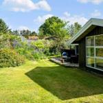 Moderne Villa mit großem Garten und Blumenbeet. Terrasse mit Sitzgelegenheit.