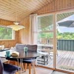 Esszimmer mit Tisch, Stühlen und Blick auf Balkon mit Garten.