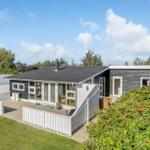 Moderne Villa mit Terrasse und Garten. Große Glasfront und Holzverkleidung.