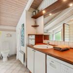 Bathroom with sink, mirror, toilet, and shower. Wood countertop and white walls.