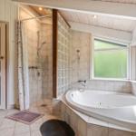 Bath with whirlpool, shower, and sauna. Windows with green glass.