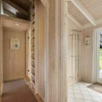 Entrance area with wooden walls, coat rack, and door to outdoor area.