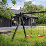 Black cabin with terrace and swing set in the garden