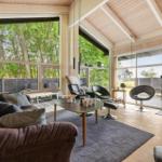Living room with sofa, chairs, and large window view of trees