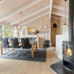 Living and dining area with fireplace, dining table, and large windows.