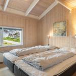 Bedroom with double bed, wood walls, and window view of the outdoors.
