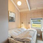 Bedroom with wooden walls, bed, and window. Small closet and wall art.