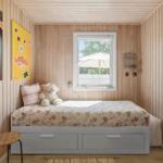 Ein Schlafzimmer mit Holzwänden, einem Bett mit Kissen und einem Teddybären.