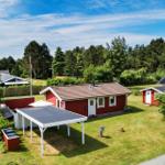 Rotes Haus mit Garage und Garten. Umgeben von Bäumen und Grasfläche.