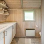 Badezimmer mit Holzwand, Waschbecken und Toilette