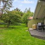 Grüner Garten mit Hängemöbel und Holzterrasse mit Sitzgruppe neben Haus.