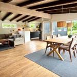 Großes Wohn- und Esszimmer mit Holzboden, Esstisch und Blick auf Garten.